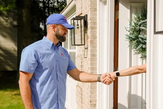 Certified HVAC technician shaking hands at a home entrance in New Jersey.