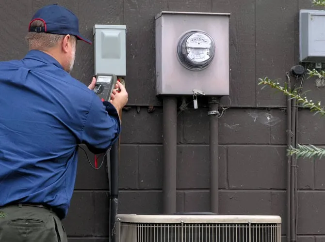 Technician inspecting outdoor electrical equipment for HVAC system in New Jersey.