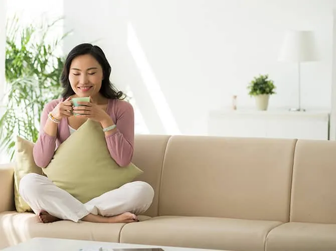 Homeowner relaxing on a couch with clean conditioned air.