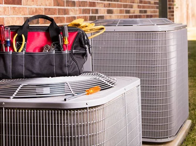 Tools and service equipment on top of HVAC units outside a house in New Jersey.