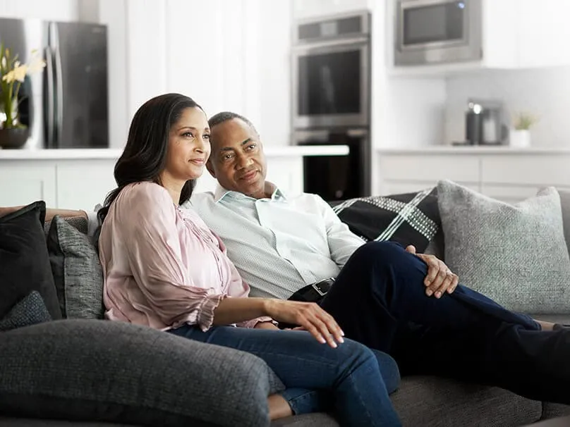 Couple relaxing comfortably at home with a high-efficiency furnace.
