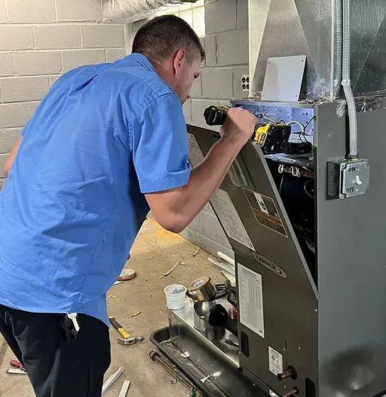 Technician inspecting a furnace that may need replacement.