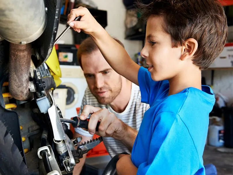 Adult helping a child with a project in a heated garage workshop.